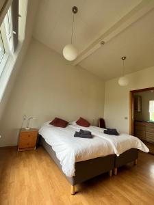 ein Schlafzimmer mit einem großen Bett mit weißer Bettwäsche und roten Kissen in der Unterkunft Skálholt Cottages in Selfoss