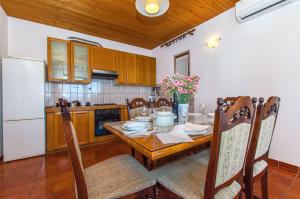 a kitchen with a wooden table and a white refrigerator at Apartment Jordan in Duće