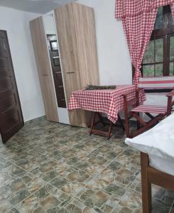 a room with a table and chairs and a kitchen at Apartmani kod Kmeta in Janja
