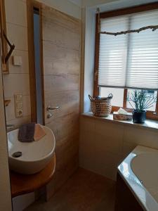 ein Bad mit einem Waschbecken, einem WC und einem Fenster in der Unterkunft Ehem. Sächsisch-Bayrischer Hof in Pöhl