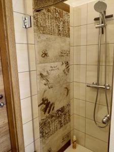 y baño con ducha y pared de azulejos. en Ehem. Sächsisch-Bayrischer Hof, en Pöhl