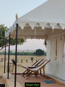 a pair of lounge chairs under a tent at Jaisalmer Safari Base & Camp in Khuri