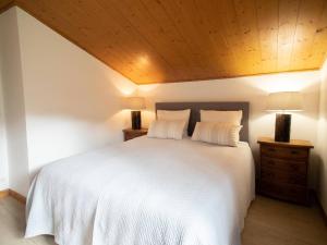 ein Schlafzimmer mit einem weißen Bett und einer Holzdecke in der Unterkunft Duplex rénové 4 pièces, 6 pers., 2 balcons, casier à skis, ménage inclus - FR-1-291-791 in Valmorel