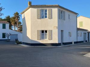 un gran edificio blanco al lado de una calle en Maison de Charme à St Clément des baleines, en Saint-Clément-des-Baleines