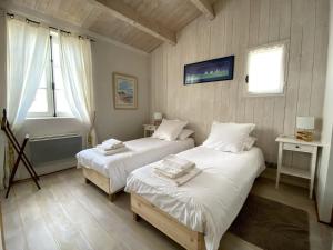 a bedroom with two beds and a window at Maison de Charme à St Clément des baleines in Saint-Clément-des-Baleines