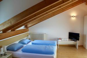 a bedroom with a bed with blue pillows at Manzoni Rooms in Merano