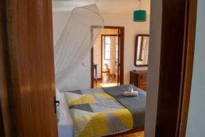 a bedroom with a bed with a yellow and gray blanket at Unique House - Pool, Terrace & Amazing View in Ribeira Brava