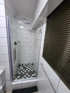 a bathroom with a shower with a checkered floor at 1901 on Hightide in Amanzimtoti