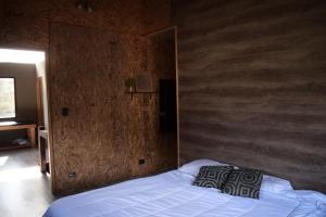 a bedroom with a bed with a wooden wall at Habitación privada en casa compartida in San Carlos de Bariloche