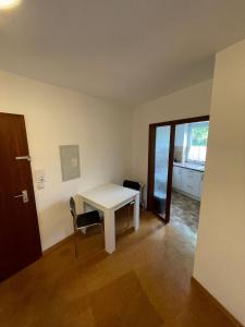 Cette chambre comprend une table blanche et une chaise. dans l'établissement 2-Zimmer Monteurwohnung mit großem Balkon, à Kiel