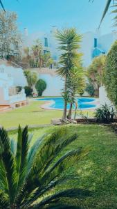 un jardín con palmeras y una piscina en Ocean View Skyline Apartment ‚Hakuna Matata‘, en Albufeira