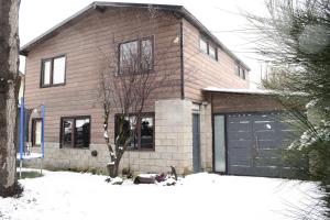 a house with a garage in the snow at Habitación privada en casa compartida in San Carlos de Bariloche