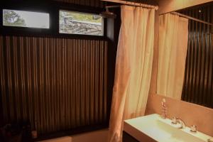 baño con lavabo, espejo y ventana en Habitación privada en casa compartida en San Carlos de Bariloche
