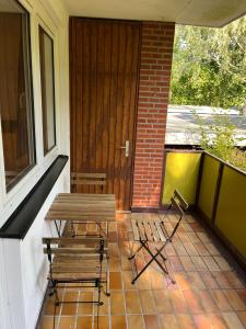 a porch with two chairs and a table on a balcony at 2-Zimmer Monteurwohnung mit großem Balkon in Kiel