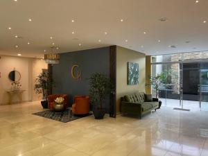 a lobby with couches and plants in a building at Hotel Catena in Cochabamba