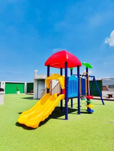 a playground with a slide on the grass at Richjones Bed & Breakfast in Manila