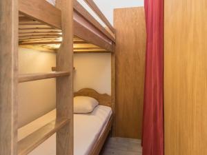1 dormitorio con 2 literas y cortina roja en Appartement Briançon, 1 pièce, 3 personnes - FR-1-330C-21 en Briançon