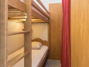 1 Schlafzimmer mit 2 Etagenbetten und einem roten Vorhang in der Unterkunft Studio cosy avec coin nuit, proche télécabine et centre, parking - FR-1-330C-21 in Briançon
