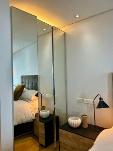 a bedroom with a mirror and a bed at Clifton Beach Apartment in Cape Town