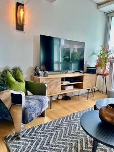 a living room with a couch and a tv at Clifton Beach Apartment in Cape Town