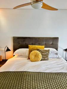a bed with pillows on it in a bedroom at Clifton Beach Apartment in Cape Town