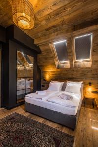 a bedroom with a large bed with a wooden wall at DzieńDobryMazury_Filip in Pozezdrze