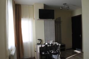 a room with a tv and a table and chairs at Hotel Tbilisi sea Terrace in Tbilisi City