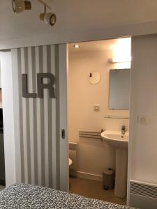 een badkamer met een bed, een wastafel en een spiegel bij Agréable Studio au Centre Ville in La Rochelle +4 foto's