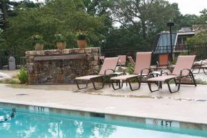 a group of chairs and a fireplace next to a swimming pool at The Residences at Biltmore - Asheville in Asheville
