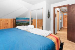 Un dormitorio con una cama grande con una manta azul. en Mountain Getaway, en Big Bear Lake