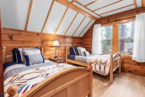 2 camas en una habitación con paredes y ventanas de madera en Mountain Getaway, en Big Bear Lake