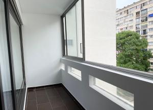 una stanza vuota con due finestre e un balcone di Le Silly - Bel appartement - Paris & Parc des Princes a Boulogne-Billancourt