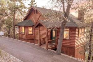 a log cabin with a porch and a tree at Bearadise Retreat in Big Bear Lake