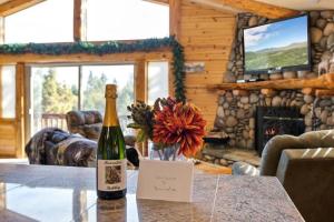 a bottle of wine and a vase with flowers on a table at Bearadise Retreat in Big Bear Lake