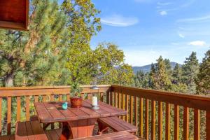 a wooden deck with a picnic table on a balcony at Bearadise Retreat in Big Bear Lake