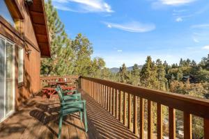 a deck with a green chair and a table at Bearadise Retreat in Big Bear Lake