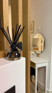 a vase filled with black sticks on top of a refrigerator at Casa Divina in Veria