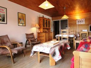 a living room with a table and chairs at Appartement Huez, 3 pièces, 6 personnes - FR-1-405-1 in L'Alpe-d'Huez
