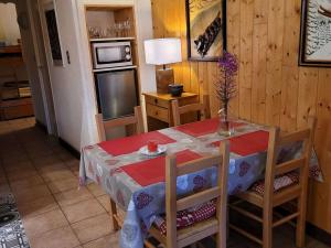 a dining room table and chairs with a table and a television at Appartement Huez, 1 pièce, 4 personnes - FR-1-405-11 in L'Alpe-d'Huez
