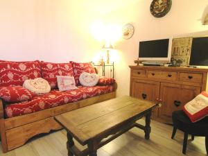 a living room with a red couch and a tv at Appartement Huez, 2 pièces, 5 personnes - FR-1-405-26 in L'Alpe-d'Huez