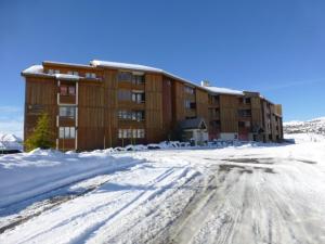 a snow covered road in front of a building at Appartement Huez, 2 pièces, 5 personnes - FR-1-405-26 in L'Alpe-d'Huez