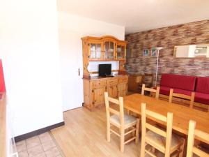 uma sala de jantar com uma mesa e um sofá vermelho em Appartement Huez, 2 pièces, 6 personnes - FR-1-405-27 em Alpe-d'Huez