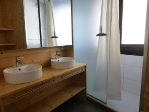 ein Badezimmer mit 2 Waschbecken und einem Spiegel in der Unterkunft Appartement Huez, 2 pièces, 8 personnes - FR-1-405-29 in L'Alpe-d'Huez