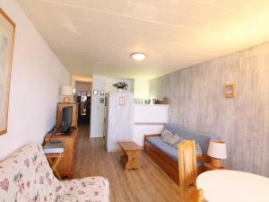 ein Wohnzimmer mit einem Sofa und einem TV in der Unterkunft Appartement Huez, 1 pièce, 4 personnes - FR-1-405-45 in L'Alpe-d'Huez
