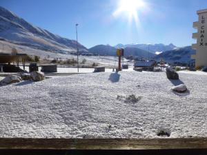 un terreno cubierto de nieve con el sol en el fondo en Appartement Huez, 1 pièce, 4 personnes - FR-1-405-45 en L'Alpe-d'Huez