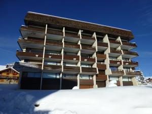 ein hohes Gebäude mit Schnee davor in der Unterkunft Appartement Huez, 1 pièce, 4 personnes - FR-1-405-45 in L'Alpe-d'Huez