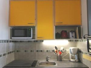 ラルプ・デュエズにあるAppartement Huez, 1 pièce, 5 personnes - FR-1-405-64のキッチン(黄色のキャビネット、シンク付)
