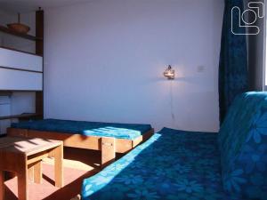 ラルプ・デュエズにあるAppartement Huez, 1 pièce, 4 personnes - FR-1-405-65のベッド2台、テーブル、ランプが備わる客室です。