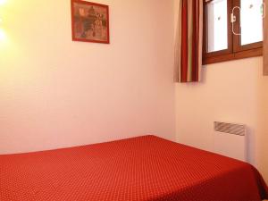 ラルプ・デュエズにあるAppartement Huez, 2 pièces, 4 personnes - FR-1-405-84の赤いベッド1台、窓が備わる客室です。