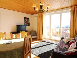 un salon avec une table et un canapé et un balcon dans l'établissement Appartement cosy à L'Alpe d'Huez, 5 pers, balcon, proche pistes et centre, animaux acceptés - FR-1-405-9, à L'Alpe-d'Huez